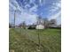 View of the side and back of a home from the yard, including a chain-link fence at 1704 E Kirk St, Muncie, IN 47303