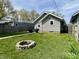 Landscaped backyard with a fire pit, a well-maintained lawn, a grill and outdoor seating in a fenced yard at 1749 E 52Nd St, Indianapolis, IN 46205