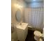 Well-lit bathroom featuring black hexagon tiles, a striped shower curtain, and a white vanity at 1749 E 52Nd St, Indianapolis, IN 46205