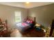 Bright bedroom with hardwood floors featuring a wood-framed bed and a window with natural light at 1749 E 52Nd St, Indianapolis, IN 46205