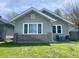 Charming single-story home with gray siding, white trim, and a brick accent with a seating area on the front patio at 1749 E 52Nd St, Indianapolis, IN 46205