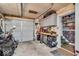 Garage with storage cabinets, work bench, motorcycle and grey roll up door at 1917 W 58Th St, Indianapolis, IN 46228