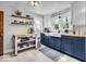 Charming kitchen features blue cabinets, butcher block counters, and open shelving at 1917 W 58Th St, Indianapolis, IN 46228