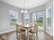 Bright dining area features a table for four, wood floors, and access to the backyard through sliding glass doors at 19283 Donelson Ln, Westfield, IN 46062