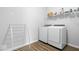 Functional laundry room featuring modern washer and dryer, wire shelving and wood-look flooring at 19283 Donelson Ln, Westfield, IN 46062