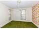 Cozy bedroom featuring green carpet, floral wallpaper, and natural light from two windows at 2001 S I St, Elwood, IN 46036