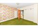 Bedroom with vintage wallpaper, green carpet, and natural light, providing a nostalgic and unique space at 2001 S I St, Elwood, IN 46036