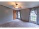 Neutral bedroom with a ceiling fan, carpet, and light-filled windows, providing a serene retreat at 2088 Brandywine Ln, Martinsville, IN 46151