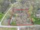 Aerial view of property outlined in red, showcasing homes, garage, and wooded acreage at 2088 Brandywine Ln, Martinsville, IN 46151