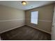 Cozy bedroom features neutral walls, plush carpeting, and natural light from the window at 2344 Orchard Creek Dr, Columbus, IN 47201