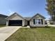 Charming single-story home with a brick facade, black garage door, and well-manicured lawn at 2344 Orchard Creek Dr, Columbus, IN 47201