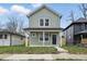 Charming two-story home featuring light green siding, a covered front porch, and a well-maintained lawn at 2352 Stuart St, Indianapolis, IN 46218