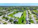 A scenic aerial view of a community with homes surrounding a pond and green spaces at 241 Green Meadow Dr, Indianapolis, IN 46229