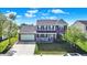 Charming two-story home with a brick facade, attached garage, and well-manicured lawn at 241 Green Meadow Dr, Indianapolis, IN 46229