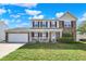 Lovely two-story home featuring brick and siding, a well-kept lawn, and an attached two-car garage at 241 Green Meadow Dr, Indianapolis, IN 46229