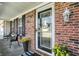 Close up of a welcoming front porch with decorative plants, a stylish door, and brick accents at 241 Green Meadow Dr, Indianapolis, IN 46229