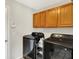 Functional laundry room featuring overhead cabinets and modern washer and dryer at 241 Green Meadow Dr, Indianapolis, IN 46229