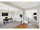 Open-concept living room and office space with a cozy fireplace, hardwood floors, and neutral paint at 241 Green Meadow Dr, Indianapolis, IN 46229