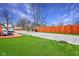 Expansive backyard featuring a gravel parking area, a red-stained deck, a privacy fence, and a lush green lawn at 2428 N Gale St, Indianapolis, IN 46218
