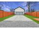 Long driveway leading to a detached garage, flanked by green grass, and enclosed with a privacy fence at 2428 N Gale St, Indianapolis, IN 46218