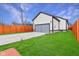 A well-maintained garage exterior with a gray garage door, complemented by a green lawn and a red-stained privacy fence at 2428 N Gale St, Indianapolis, IN 46218