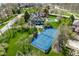 An aerial shot displays the tennis court and beautiful home situated on a well-maintained lot at 290 Breakwater Dr, Fishers, IN 46037