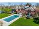 Stunning aerial view of a brick home with a large pool, manicured lawn, and mature trees at 290 Breakwater Dr, Fishers, IN 46037