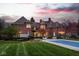 Beautiful brick home featuring a large pool, manicured lawn, and lush landscaping at 290 Breakwater Dr, Fishers, IN 46037