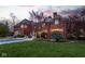 Brick home boasts a gorgeous backyard with mature trees, patio seating and an inviting pool at 290 Breakwater Dr, Fishers, IN 46037