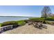 Patio with a fire pit and seating area overlooking a serene lake view at 290 Breakwater Dr, Fishers, IN 46037