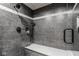 Modern bathroom shower featuring dark marble-style tile, a built-in bench, and rainfall showerhead at 290 Breakwater Dr, Fishers, IN 46037