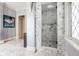 Luxurious bathroom with marble floors, marble walls, a glass shower, and leaded glass window at 290 Breakwater Dr, Fishers, IN 46037