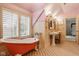Bright bathroom with a clawfoot tub, double sinks, natural light, and wainscoting at 290 Breakwater Dr, Fishers, IN 46037