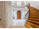 Elegant foyer with curved staircase, wood front door, and marble floors at 290 Breakwater Dr, Fishers, IN 46037