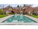 Gorgeous backyard pool with lounge area and umbrellas, complemented by a classic brick home at 290 Breakwater Dr, Fishers, IN 46037