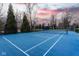 Well-maintained blue tennis court surrounded by mature trees at 290 Breakwater Dr, Fishers, IN 46037