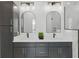 Modern bathroom featuring double vanity with sleek countertops, dark cabinetry, and arched mirrors at 315 E Minnesota St, Indianapolis, IN 46225