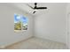 A carpeted bedroom featuring a ceiling fan and a large window with natural light at 315 E Minnesota St, Indianapolis, IN 46225