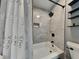 Clean bathroom with a white tub, tiled shower, and a decorative shower curtain, creating a refreshing space at 334 N Chester Ave, Indianapolis, IN 46201