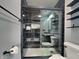 Modern bathroom with a black and white marble-patterned tiled shower, sleek glass door, and black fixtures at 334 N Chester Ave, Indianapolis, IN 46201