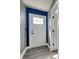 Home entryway featuring a white door, dark hardware, blue accent wall, and wood floors at 334 N Chester Ave, Indianapolis, IN 46201