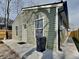 Exterior side view of home with light green siding, white trim and black trash bag outside at 334 N Chester Ave, Indianapolis, IN 46201
