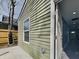 An exterior corner shot featuring light green siding, white trim, and a view to the interior hallway at 334 N Chester Ave, Indianapolis, IN 46201