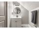Modern bathroom features a round mirror, vanity with cabinet storage, and sleek, black hardware and fixtures at 341 Sanders St, Indianapolis, IN 46225