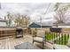 Back deck has wood floors, a grill and seating area with a view of the wooden fence and other homes at 341 Sanders St, Indianapolis, IN 46225