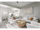 Open-concept living room with gray walls, light wood floors, a sectional couch, and decoratively patterned area rug at 341 Sanders St, Indianapolis, IN 46225