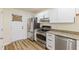 Modern kitchen boasts stainless steel appliances, granite countertops, and sleek white cabinetry at 3624 Wallace Ave, Indianapolis, IN 46218