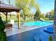 Backyard featuring pool, covered patio, and lounge chairs surrounded by well manicured landscape at 4414 Hickory Grove Blvd, Greenwood, IN 46143