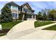 Beautiful two-story house with an expansive driveway and lush greenery in a suburban setting at 4414 Hickory Grove Blvd, Greenwood, IN 46143