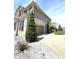 Side view of home with two car garage, stone accents, landscaped yard, and concrete driveway at 4414 Hickory Grove Blvd, Greenwood, IN 46143